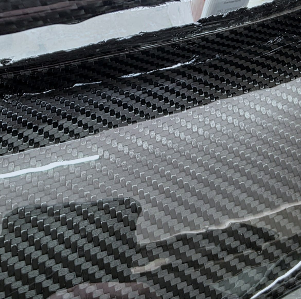 Close view of the 2x2 twill carbon-fibre weave on a finished Gapped Performance grille.